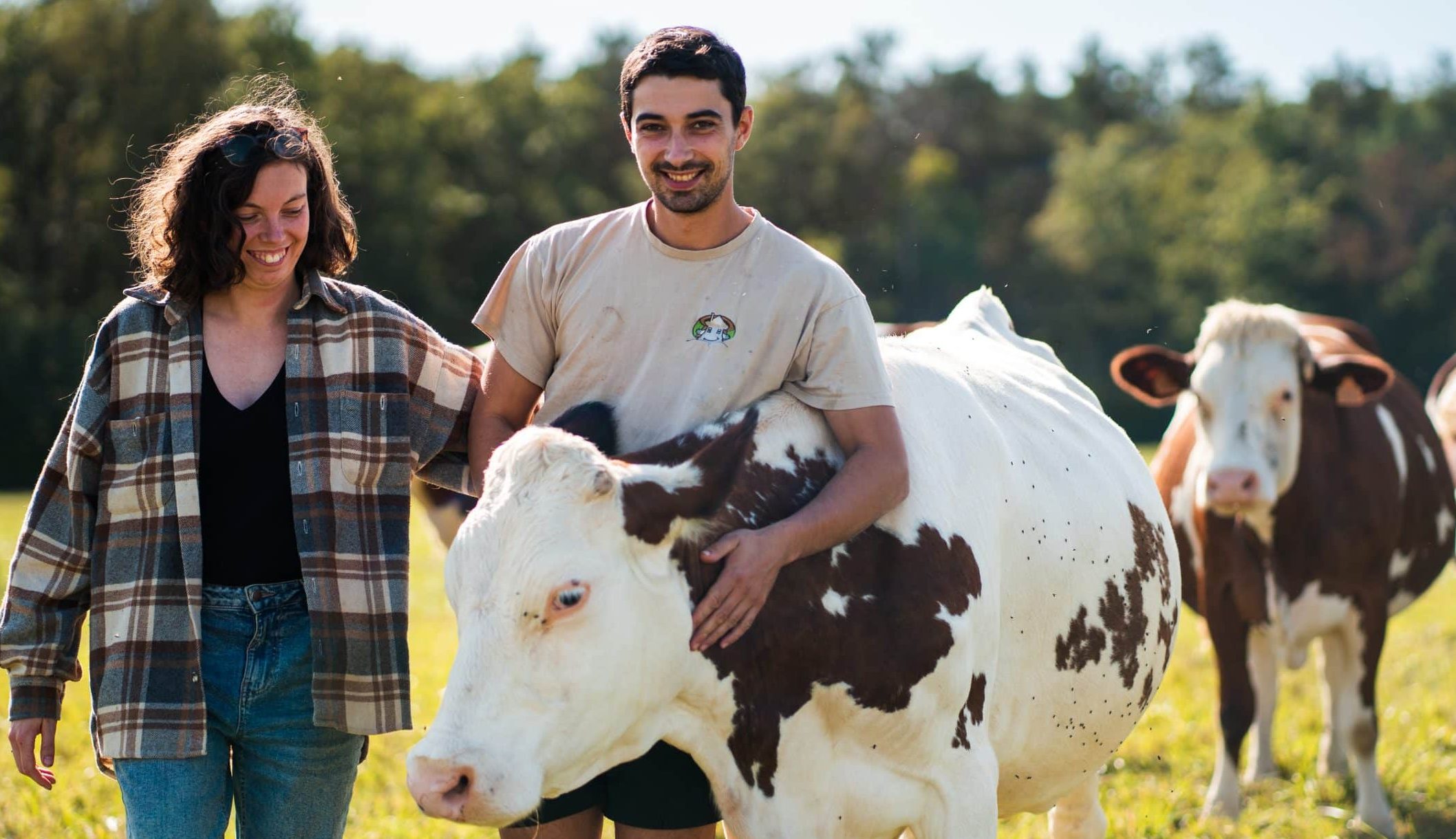 Maxime et Sophie de la Ferme bio Thorey avec leurs vaches au pré, à Lantages